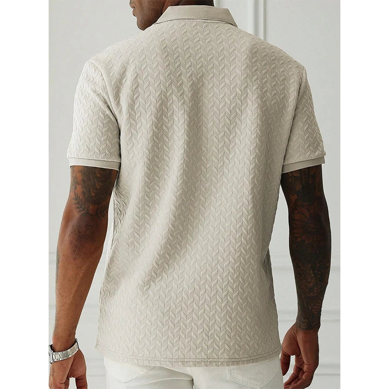 Beige textured polo shirt with herringbone pattern, worn by man with tattooed arms, stylish streetwear