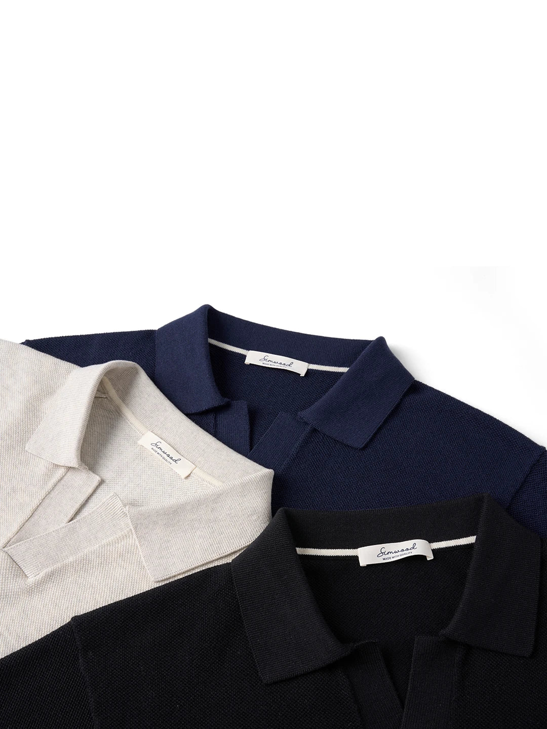 Three classic polo shirts in navy, black, and cream with brand tags, ideal for everyday wear and streetwear styles.