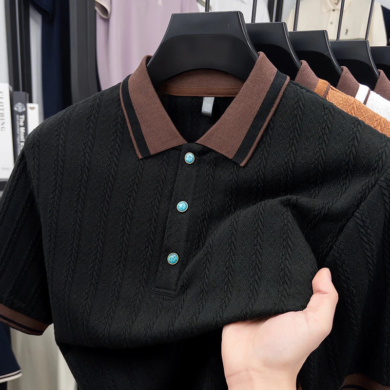 Black textured polo shirt with brown collar and teal buttons, held on hanger in clothing store